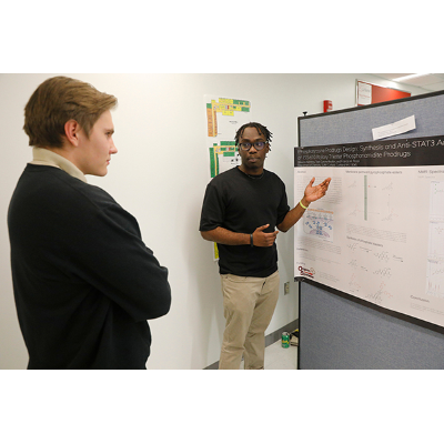 Odurosi Kwarteng, right, explains poster