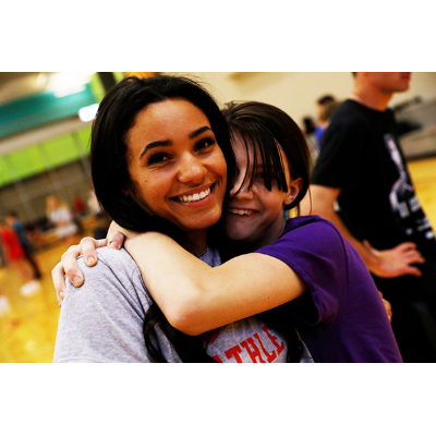 A SUNY Cortland student  hugs a Cortland Stars Special Olympics club community participant.