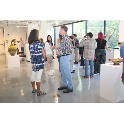 Edward Feldman '95, right, speaks with a gallery visitor.