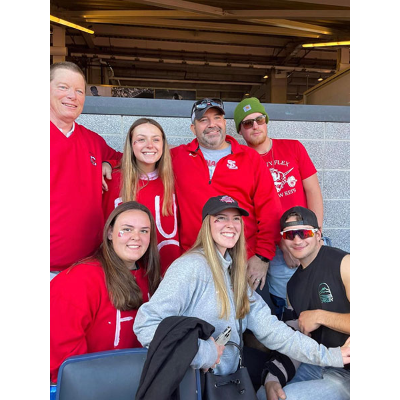 Dann at 2022 Cortaca Jug at Yankee Stadium with, front row, Katelyn Gay ’24, Madelyn Gay ’24 and Braden Ryan; and back row, Mark Farmer ’83, Nora Glover ’24, Dann and Jackson Hunt-Lamb