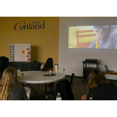 Students watching The Planet of the Apes at the Gorilla Corps showing, featuring a trifold about the environmental impact of Halloween.