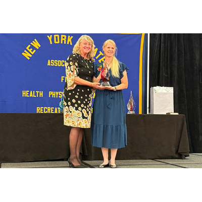 Baert, right, accepts her award from Lori Cring Bifarella ’87, 2025 president of NYS AHPERD.