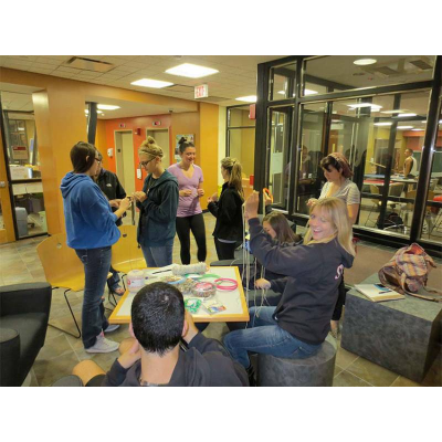 Students doing a craft with sting and beads in Alger Hall