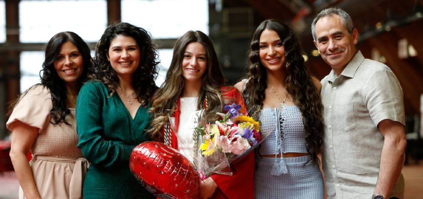 graduate smiling for photo with family members at 2023 commencement reception