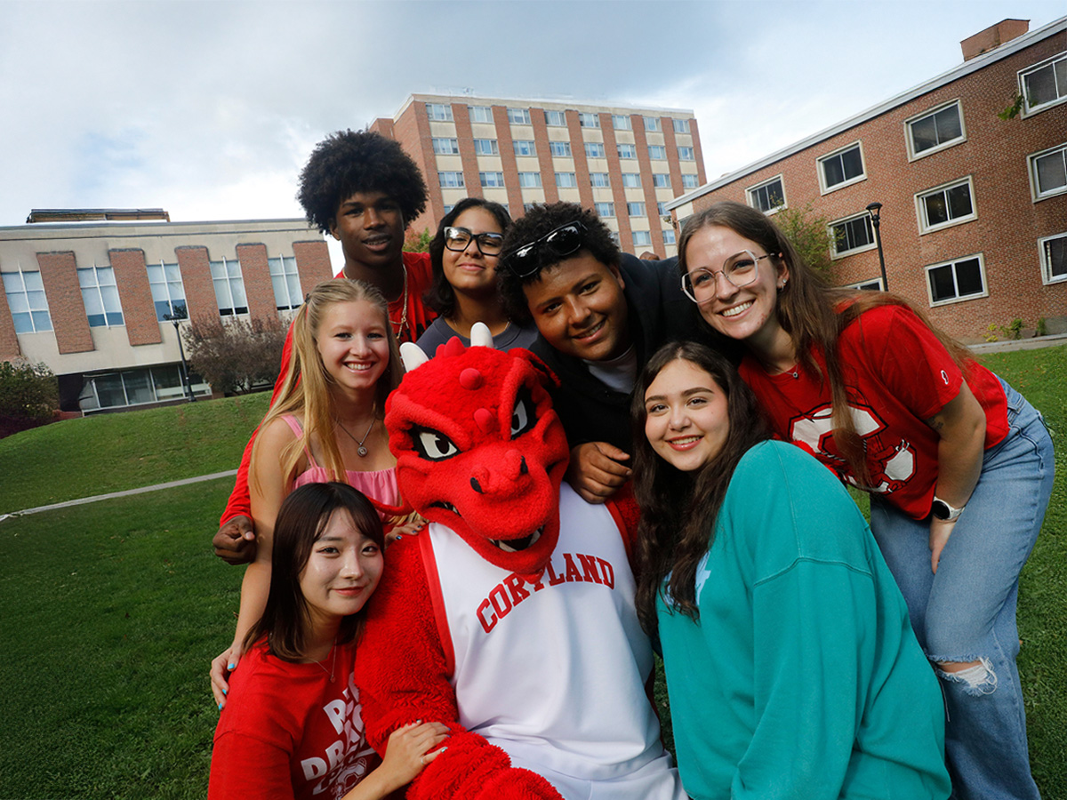 group of seven students pose with Blaze the red dragon mascot