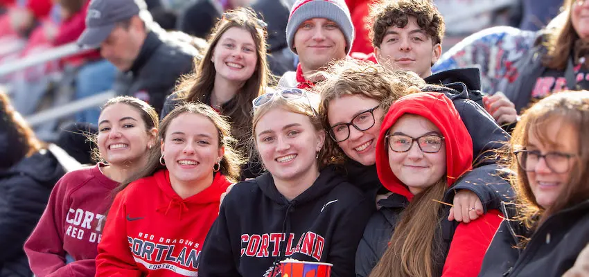 Family wearing Cortland gear at the stadium for the Family Weekend football game