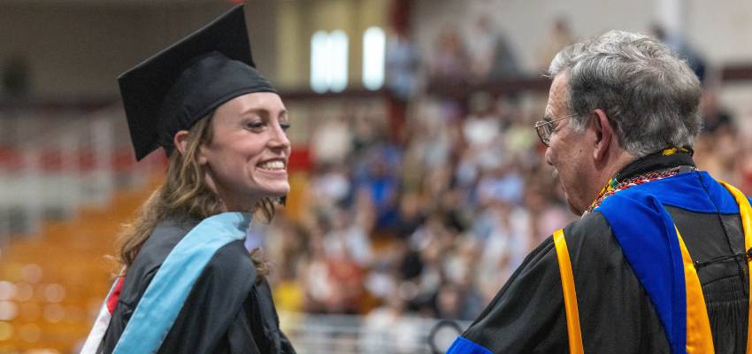 smiling student with president bitterbaum at 2025 graduate commencement