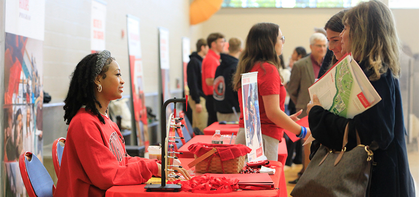 Student Government representative speaks with a prosepctive student and her mother at the Fall Open House