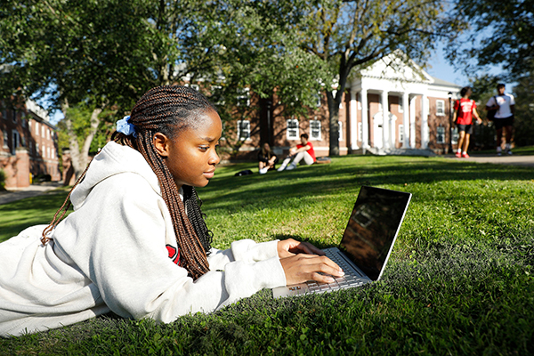 Student studying on grass outside