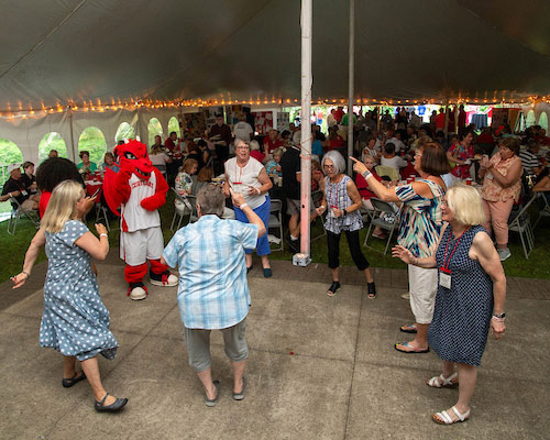Blaze the Red Dragon mascot dances with alumni at reunion