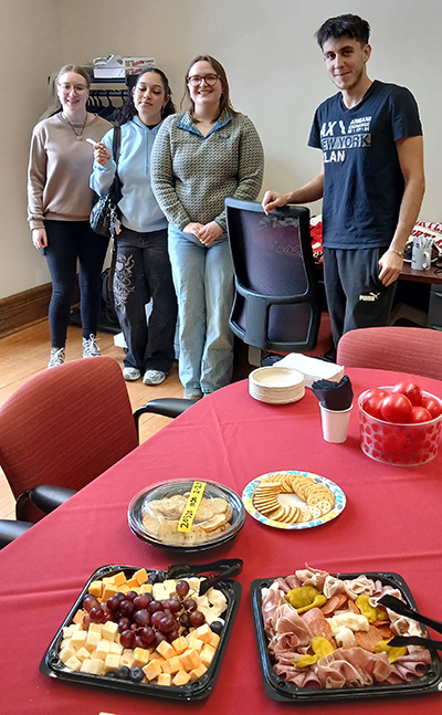 Four international studies students attend a gathering with treats