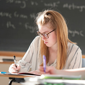 MA English student writing in a classroom