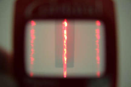 an EXIT sign in Bowers hall viewed from below and through a diffraction grating