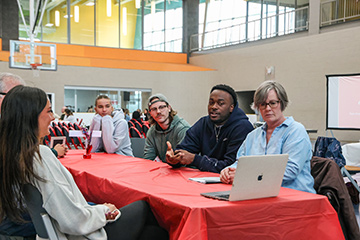 Innovation Day participants talk around a table.