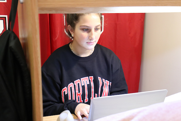 Student in residence hall working on laptop