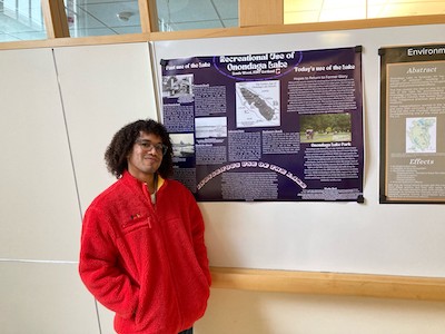 Student standing next to a research poster