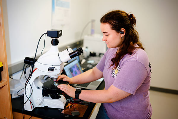 Student viewing crystals under microscope