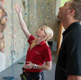 Physical Education Leadership student giving safety instructions on rock climbing