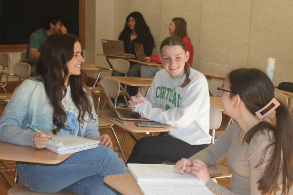 Students chatting in groups in a classroom