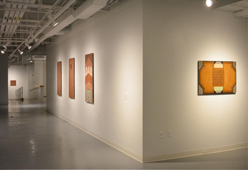 Alt text: View into the central gallery at Dowd Gallery featuring sculptural objects produced by Buffalo-based sculptor Gary Sczerbaniewicz.